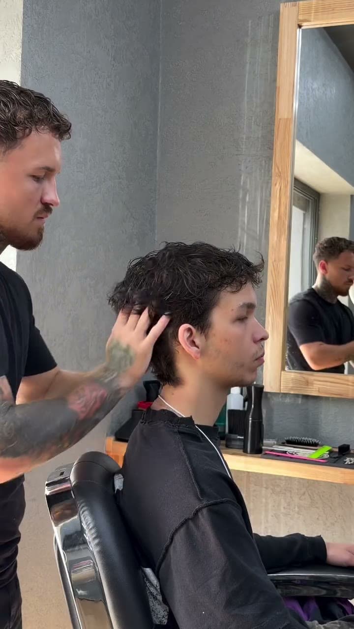 Cutting curly hair wet at the mirror